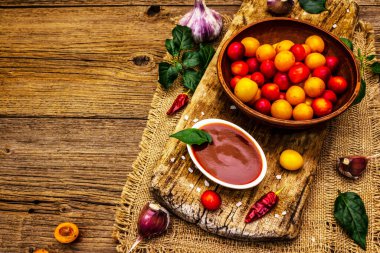 Sarımsaklı ve acı biberli Tkemali Gürcü kiraz sosu. Olgun meyve ve baharatlardan geleneksel sos. Vintage ahşap arkaplan, kopyalama alanı