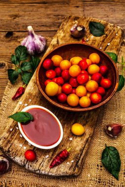 Sarımsaklı ve acı biberli Tkemali Gürcü kiraz sosu. Olgun meyve ve baharatlardan geleneksel sos. Vintage ahşap arkaplan, kapat