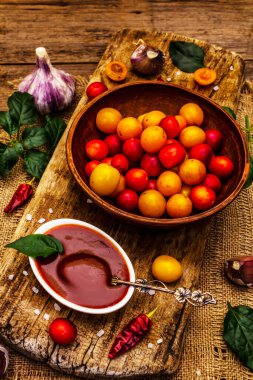Sarımsaklı ve acı biberli Tkemali Gürcü kiraz sosu. Olgun meyve ve baharatlardan geleneksel sos. Vintage ahşap arkaplan, kapat