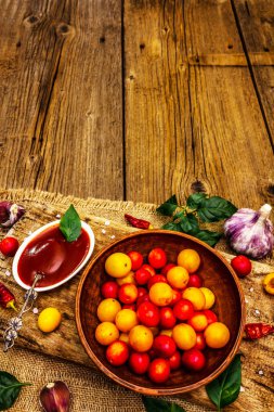 Sarımsaklı ve acı biberli Tkemali Gürcü kiraz sosu. Olgun meyve ve baharatlardan geleneksel sos. Vintage ahşap arkaplan, kopyalama alanı