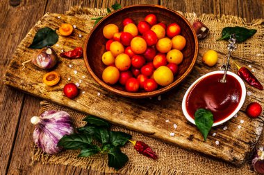 Sarımsaklı ve acı biberli Tkemali Gürcü kiraz sosu. Olgun meyve ve baharatlardan geleneksel sos. Vintage ahşap arkaplan, kapat