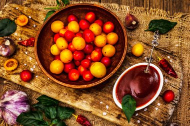 Sarımsaklı ve acı biberli Tkemali Gürcü kiraz sosu. Olgun meyve ve baharatlardan geleneksel sos. Vintage ahşap arkaplan, üst görünüm