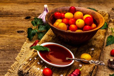 Sarımsaklı ve acı biberli Tkemali Gürcü kiraz sosu. Olgun meyve ve baharatlardan geleneksel sos. Vintage ahşap arkaplan, kopyalama alanı