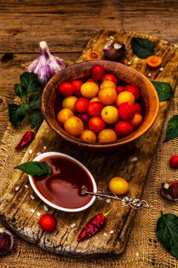 Sarımsaklı ve acı biberli Tkemali Gürcü kiraz sosu. Olgun meyve ve baharatlardan geleneksel sos. Vintage ahşap arkaplan, kapat