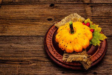 Sonbahar ve Şükran Günü yemeği. Balkabağı ve böğürtlen hasadı, renkli yapraklar, seramik tabaklar ve eski peçete. Çatal bıçak takımı ahşap arkaplan, kopyalama alanı