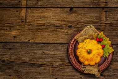 Sonbahar ve Şükran Günü yemeği. Balkabağı ve böğürtlen hasadı, renkli yapraklar, seramik tabaklar ve eski peçete. Çatal bıçak takımı ahşap arka plan, üst görünüm