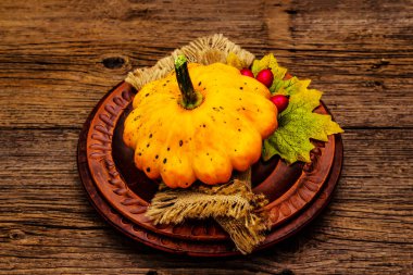 Sonbahar ve Şükran Günü yemeği. Balkabağı ve böğürtlen hasadı, renkli yapraklar, seramik tabaklar ve eski peçete. Çatal bıçak takımı ahşap arka plan, kapat