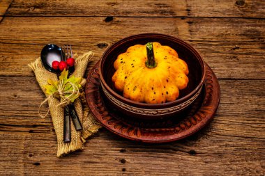 Sonbahar ve Şükran Günü yemeği. Balkabağı ve böğürtlen hasadı, renkli yapraklar, seramik tabaklar, çatal ve kaşık, antika peçete. Çatal bıçak takımı ahşap arka plan