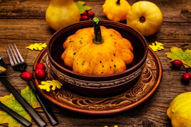 Sonbahar ve Şükran Günü yemeği. Balkabağı ve böğürtlen hasadı, renkli yapraklar, seramik tabak ve kase, çatal, kaşık ve meşe palamudu. Çatal bıçak takımı ahşap arka plan, kapat