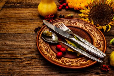 Sonbahar ve Şükran Günü yemeği. Balkabağı ve böğürtlen hasadı renkli yapraklar, seramik tabaklar, çatal, kaşık ve bıçak. Çatal bıçak takımı ahşap arkaplan, kopyalama alanı