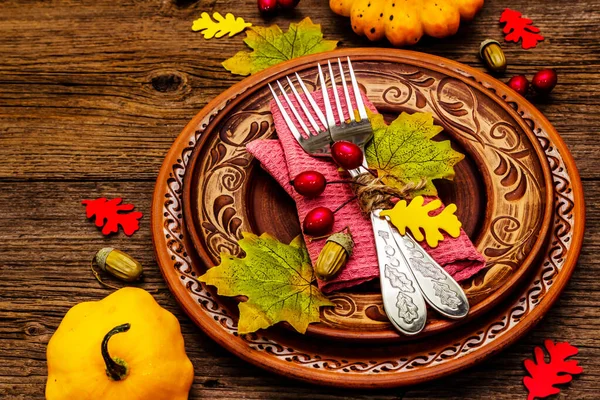 Sonbahar ve Şükran Günü yemeği. Balkabağı ve böğürtlen hasadı renkli yapraklar, seramik tabaklar, çatallar ve peçete. Çatal bıçak takımı ahşap arkaplan, kopyalama alanı