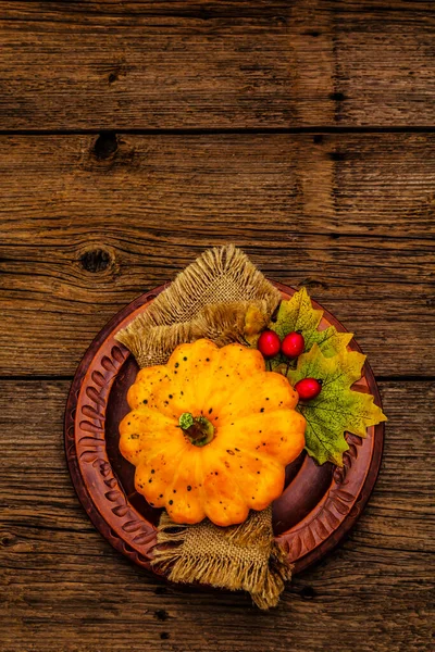 Sonbahar ve Şükran Günü yemeği. Balkabağı ve böğürtlen hasadı, renkli yapraklar, seramik tabaklar ve eski peçete. Çatal bıçak takımı ahşap arka plan, üst görünüm