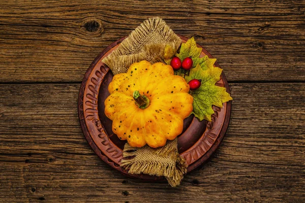 Sonbahar ve Şükran Günü yemeği. Balkabağı ve böğürtlen hasadı, renkli yapraklar, seramik tabaklar ve eski peçete. Çatal bıçak takımı ahşap arka plan, üst görünüm