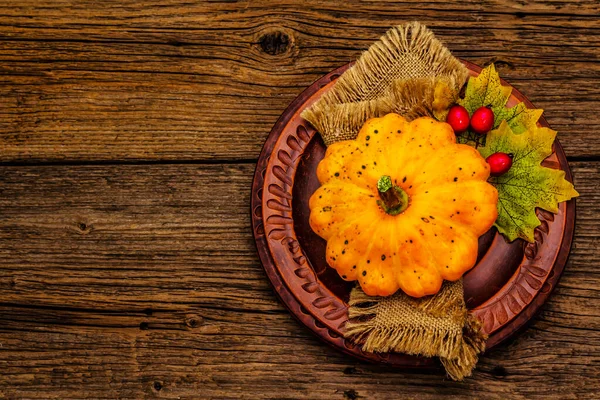 Sonbahar ve Şükran Günü yemeği. Balkabağı ve böğürtlen hasadı, renkli yapraklar, seramik tabaklar ve eski peçete. Çatal bıçak takımı ahşap arka plan, üst görünüm