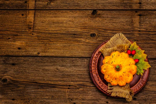 Sonbahar ve Şükran Günü yemeği. Balkabağı ve böğürtlen hasadı, renkli yapraklar, seramik tabaklar ve eski peçete. Çatal bıçak takımı ahşap arka plan, üst görünüm