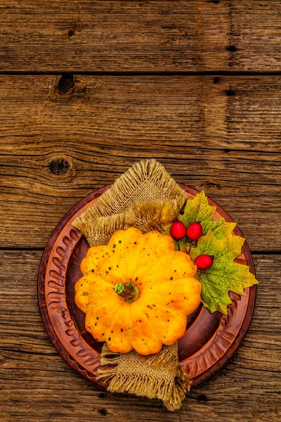 Sonbahar ve Şükran Günü yemeği. Balkabağı ve böğürtlen hasadı, renkli yapraklar, seramik tabaklar ve eski peçete. Çatal bıçak takımı ahşap arka plan, üst görünüm