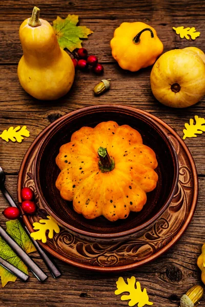 Sonbahar ve Şükran Günü yemeği. Balkabağı ve böğürtlen hasadı, renkli yapraklar, seramik tabak ve kase, çatal, kaşık ve meşe palamudu. Çatal bıçak takımı ahşap arka plan, kapat