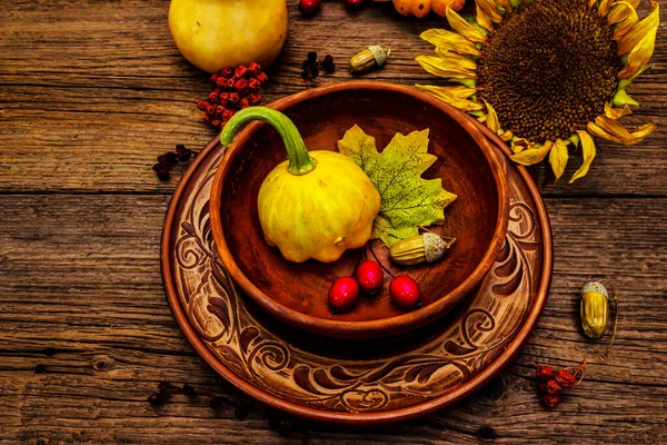 Sonbahar ve Şükran Günü yemeği. Balkabağı ve böğürtlen hasadı, renkli yapraklar, seramik tabak ve kase, ayçiçeği ve rowan. Çatal bıçak takımı ahşap arka plan, kapat