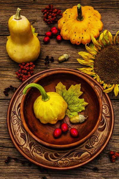 Sonbahar ve Şükran Günü yemeği. Balkabağı ve böğürtlen hasadı, renkli yapraklar, seramik tabak ve kase, ayçiçeği ve rowan. Çatal bıçak takımı ahşap arka plan, kapat