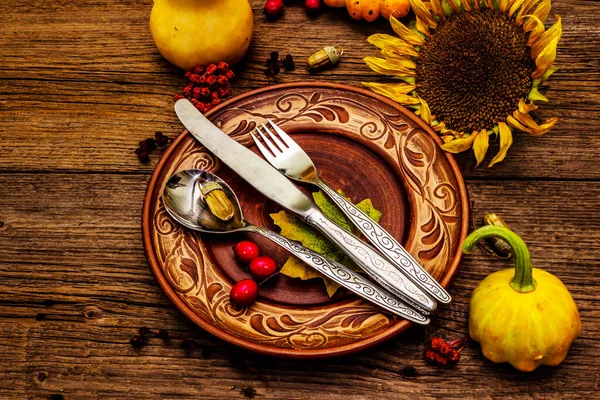 Sonbahar ve Şükran Günü yemeği. Balkabağı ve böğürtlen hasadı renkli yapraklar, seramik tabaklar, çatal, kaşık ve bıçak. Çatal bıçak takımı ahşap arkaplan, kopyalama alanı