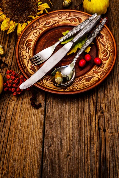 Sonbahar ve Şükran Günü yemeği. Balkabağı ve böğürtlen hasadı renkli yapraklar, seramik tabaklar, çatal, kaşık ve bıçak. Çatal bıçak takımı ahşap arkaplan, kopyalama alanı