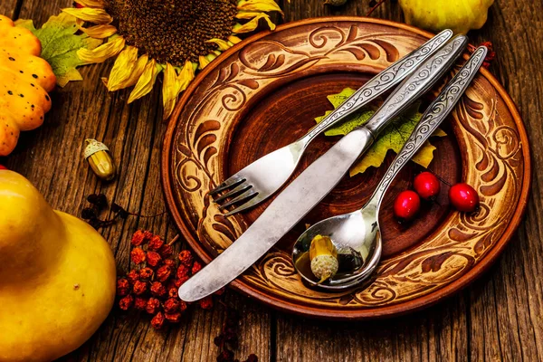 Sonbahar ve Şükran Günü yemeği. Balkabağı ve böğürtlen hasadı renkli yapraklar, seramik tabaklar, çatal, kaşık ve bıçak. Çatal bıçak takımı ahşap arka plan, kapat