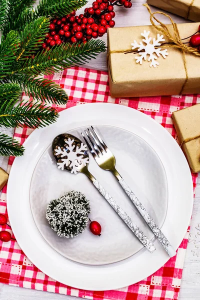 クリスマスや新年の廃棄物ゼロディナーの場所の設定 セラミックプレート ギフト スノーフレーク ブライアベリー テーマ別の装飾 白い木の板の上のお祭りのカトラリー クローズアップ — ストック写真