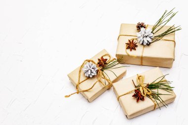 Sıfır atık hediye konsepti. Yılbaşı ya da yeni yıl dekoru çam kozalakları, yıldız anason ve klasik iplik. Plastiksiz geri dönüşümlü yaşam biçimi, beyaz macun arkaplanı, kopyalama alanı