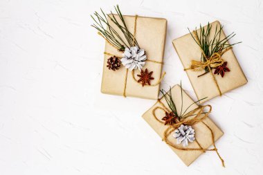Sıfır atık hediye konsepti. Yılbaşı ya da yeni yıl dekoru çam kozalakları, yıldız anason ve klasik iplik. Plastiksiz geri dönüşümlü yaşam tarzı, beyaz macun arkaplan, üst görünüm