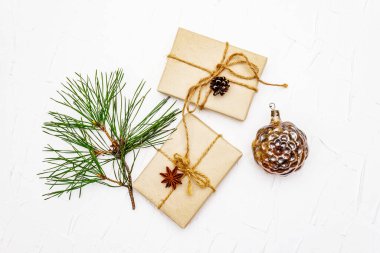 Sıfır atık hediye konsepti. Noel ya da yeni yıl dekoru, kozalak ve dallardan, parlak oyuncaklardan, yıldız anasonlarından ve klasik ipliklerden. Plastiksiz geri dönüşümlü yaşam tarzı, beyaz macun arkaplan, üst görünüm