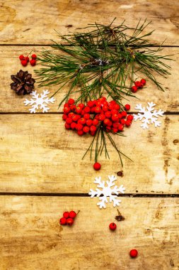 Noel ya da yeni yıl konsepti. Taze çam dalları, olgun yaban mersini, kar taneleri ve çam kozalakları. Eski ahşap zemin, üst manzara
