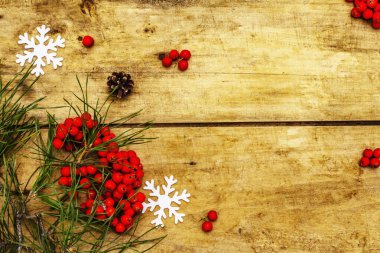 Noel ya da yeni yıl konsepti. Taze çam dalları, olgun yaban mersini, kar taneleri ve çam kozalakları. Eski ahşap zemin, üst manzara