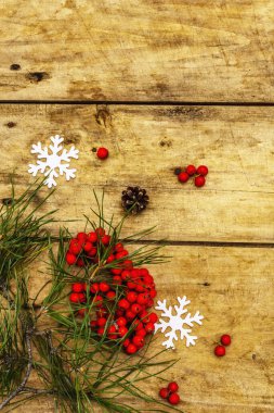 Noel ya da yeni yıl konsepti. Taze çam dalları, olgun yaban mersini, kar taneleri ve çam kozalakları. Eski ahşap zemin, üst manzara
