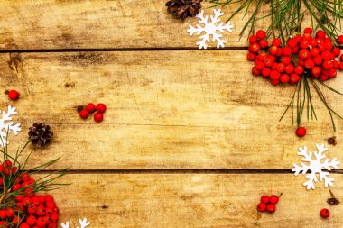 Noel ya da yeni yıl konsepti. Taze çam dalları, olgun yaban mersini, kar taneleri ve çam kozalakları. Eski ahşap zemin, üst manzara