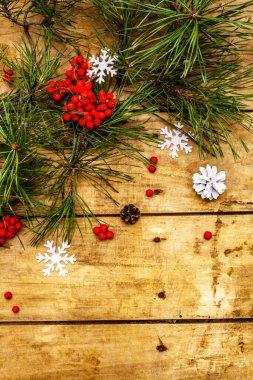 Noel ya da yeni yıl konsepti. Taze çam dalları, olgun yaban mersini, kar taneleri ve çam kozalakları. Eski ahşap zemin, üst manzara