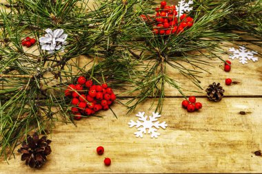 Noel ya da yeni yıl konsepti. Taze çam dalları, olgun yaban mersini, kar taneleri ve çam kozalakları. Eski tahta arkaplan, kopyalama alanı