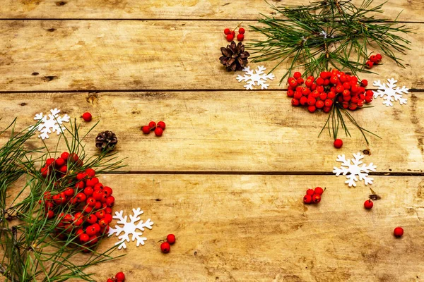 圣诞节或新年的概念 新鲜的松树枝条 成熟的树莓 雪花和松果 旧木制背景 顶视图 — 图库照片
