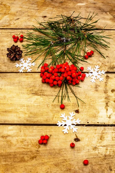 Noel ya da yeni yıl konsepti. Taze çam dalları, olgun yaban mersini, kar taneleri ve çam kozalakları. Eski ahşap zemin, üst manzara