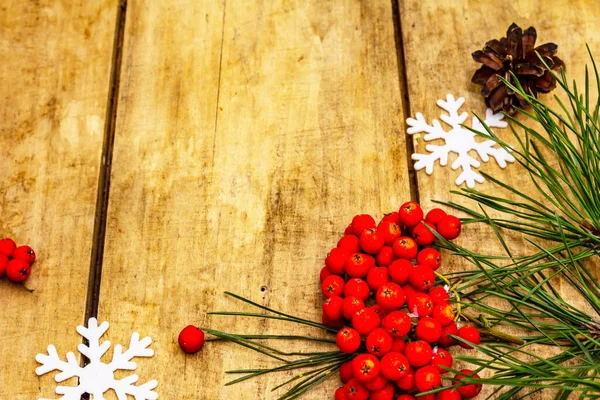 Noel ya da yeni yıl konsepti. Taze çam dalları, olgun yaban mersini, kar taneleri ve çam kozalakları. Eski tahta arkaplan, kopyalama alanı