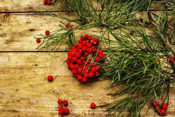 Noel ya da yeni yıl konsepti. Taze çam dalları, olgun yaban mersini, kar taneleri ve çam kozalakları. Eski tahta arkaplan, kopyalama alanı