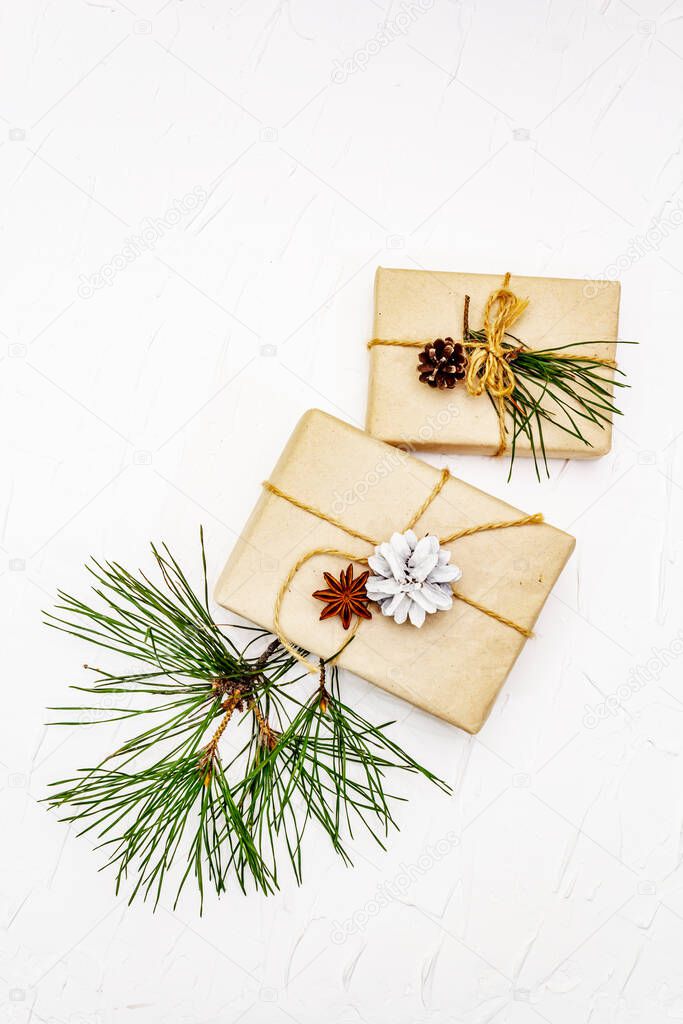 Zero waste gift concept. Christmas or New Year decor from pine branches and cones, star anise and vintage thread. Plastic-free recyclable lifestyle, white putty background, top view