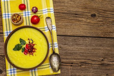 Taze sebzeli, otlu ve baharatlı mısır kremalı çorba. Klasik sonbahar sıcak yemeği, eski ahşap tahta arka plan, üst manzara.