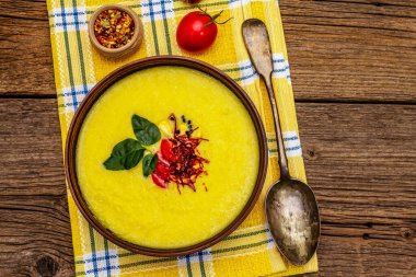 Taze sebzeli, otlu ve baharatlı mısır kremalı çorba. Klasik sonbahar sıcak yemeği, eski ahşap tahta arka plan, üst manzara.