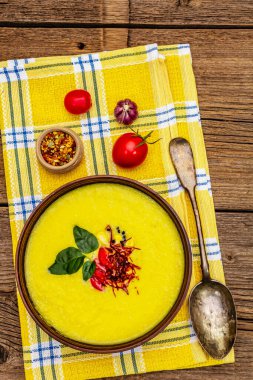 Taze sebzeli, otlu ve baharatlı mısır kremalı çorba. Klasik sonbahar sıcak yemeği, eski ahşap tahta arka plan, kapat