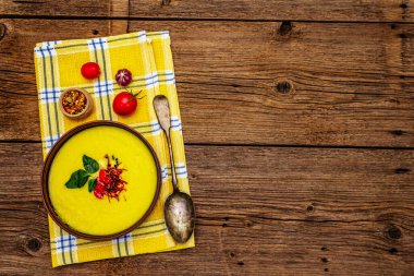 Taze sebzeli, otlu ve baharatlı mısır kremalı çorba. Klasik sonbahar sıcak yemeği, eski ahşap tahta arka plan, üst manzara.