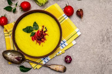 Taze sebzeli, otlu ve baharatlı mısır kremalı çorba. Klasik sonbahar yemeği, taş beton arka plan, üst görünüm.