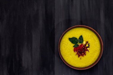 Taze sebzeli, otlu ve baharatlı mısır kremalı çorba. Klasik sonbahar sıcak yemeği, siyah ahşap arka plan, üst manzara.