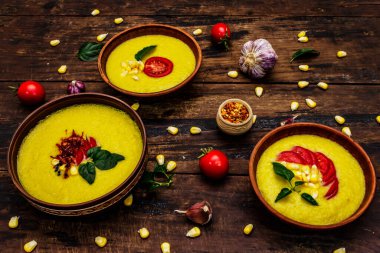 Taze sebzeli, otlu ve baharatlı mısır kremalı çorba. Klasik sonbahar sıcak yemeği, eski ahşap masa, yakın çekim.