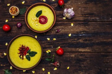 Taze sebzeli, otlu ve baharatlı mısır kremalı çorba. Klasik sonbahar sıcak yemeği, eski ahşap masa, üst manzara.