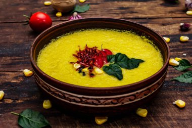 Taze sebzeli, otlu ve baharatlı mısır kremalı çorba. Klasik sonbahar sıcak yemeği, eski ahşap masa, yakın çekim.